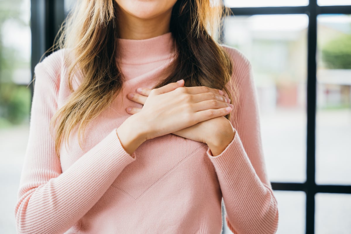 woman touching her chest for thanking at home